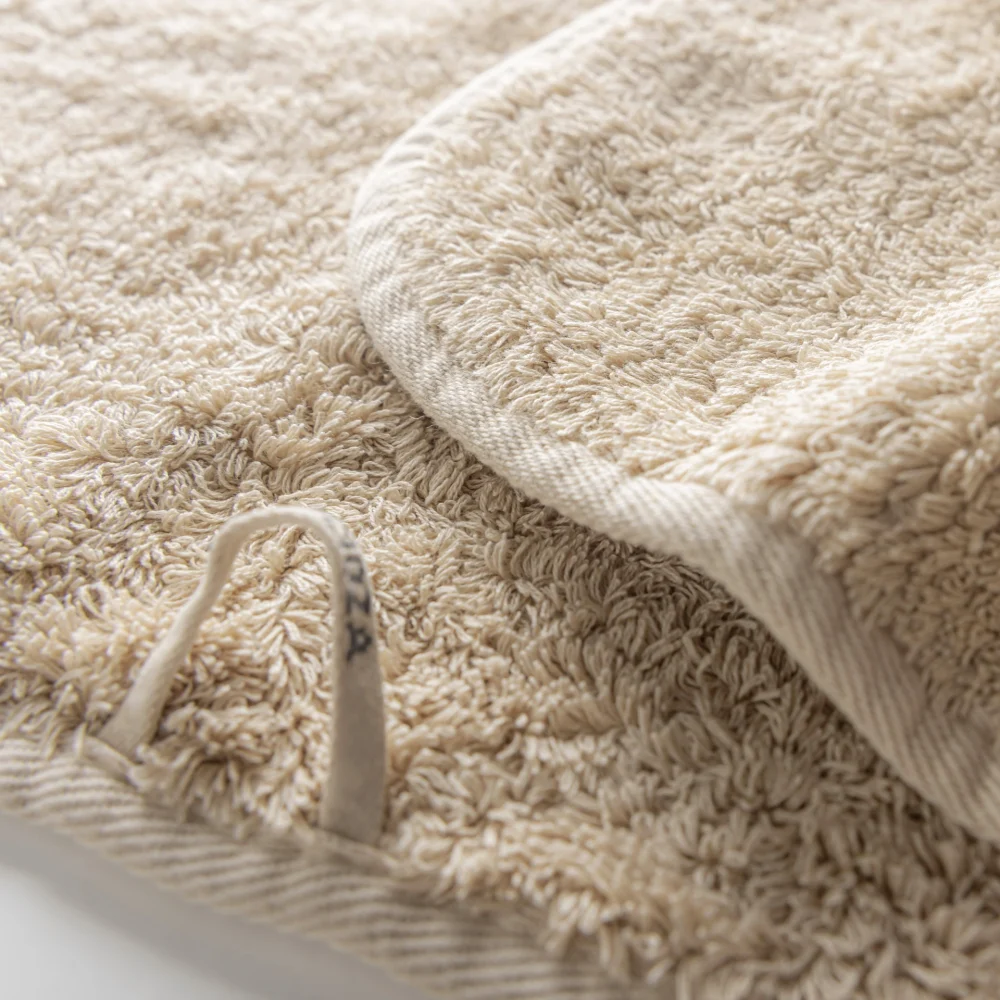 Närbild på den kraftiga hängöglan i bomull samt de täta frottéöglorna på en Linen Graccioza Egoist-handduk.